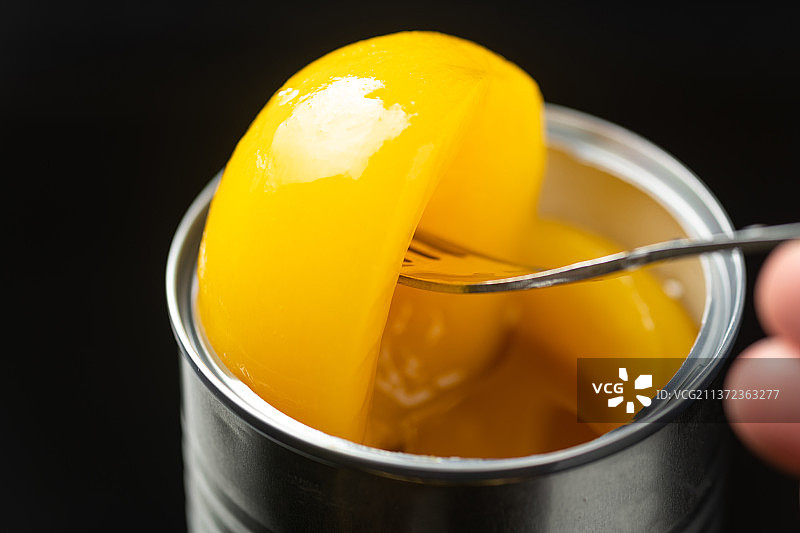 一碗黄桃罐头特写黑色背景图片素材