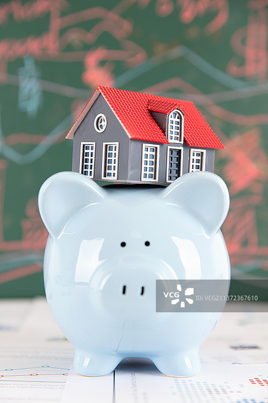 顶着小房子模型的小猪存钱罐图片素材