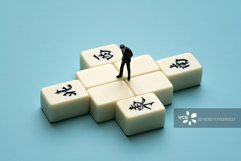 一个穿着正装的男士焦虑的站在麻将中图片素材