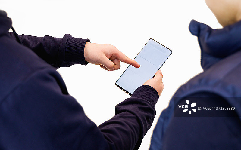 一个人给另一个人展示手机上的内容图片素材