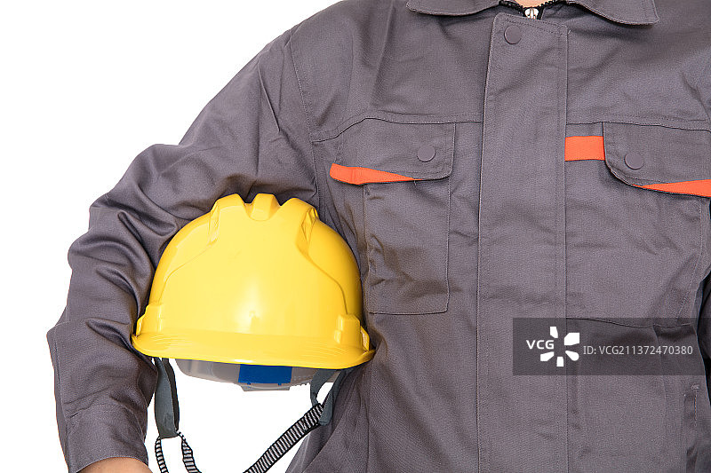 建筑农民工胳膊下夹着黄色的安全帽图片素材