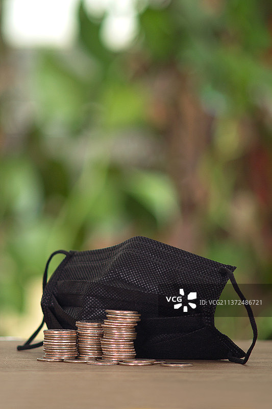 医用一次性口罩和一堆美元硬币图片素材