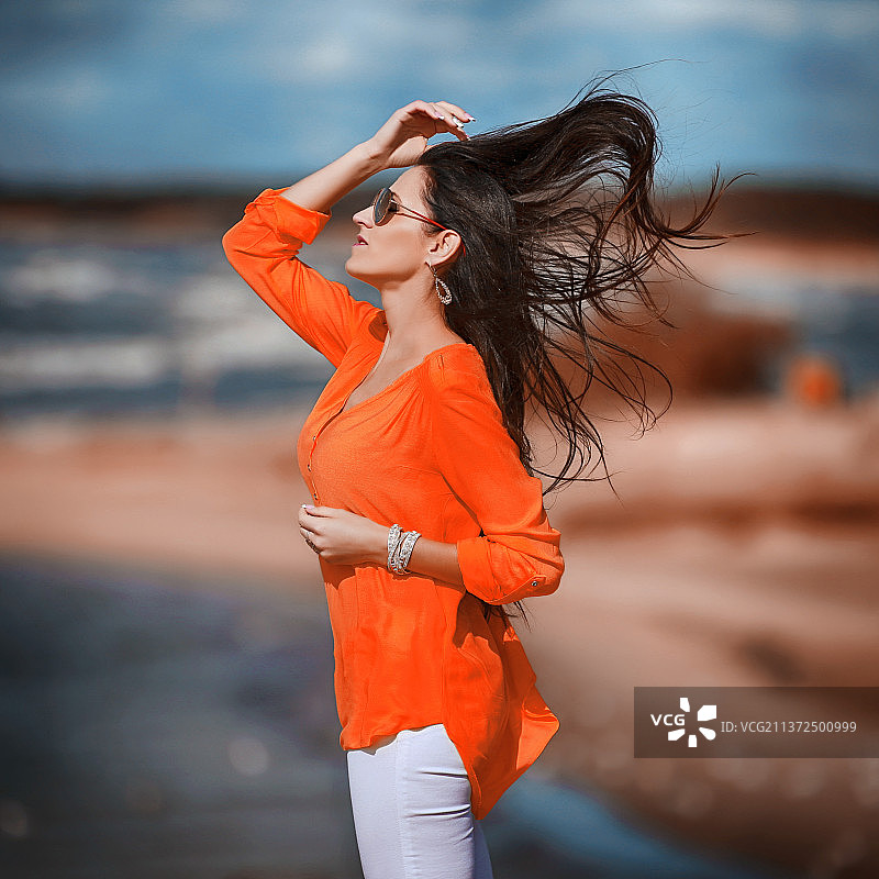 头发蓬乱的年轻女人站在立陶宛的道路上图片素材