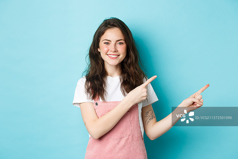 微笑的可爱少女指向促销内容图片素材