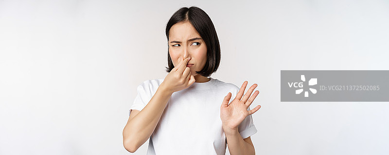 亚洲女孩厌恶地看着，拒绝有异味的产品，关闭图片素材