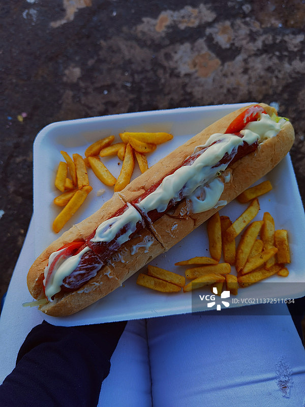 切过的手拿着热狗和薯条图片素材
