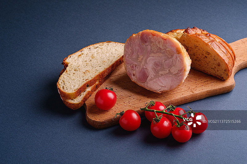 火鸡火腿肉，奶酪面包和樱桃番茄的侧面视角（木板上）图片素材