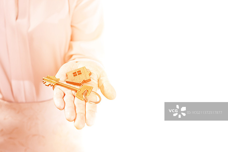 购买房屋：手持房屋钥匙，白色背景图片素材