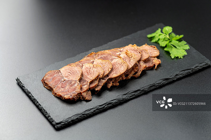 一盘酱牛肉切片特写黑色背景图片素材