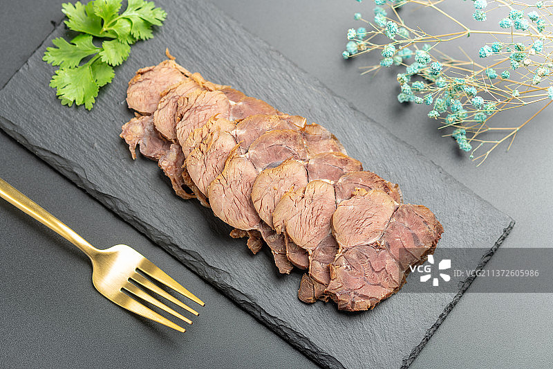一盘酱牛肉切片特写黑色背景图片素材