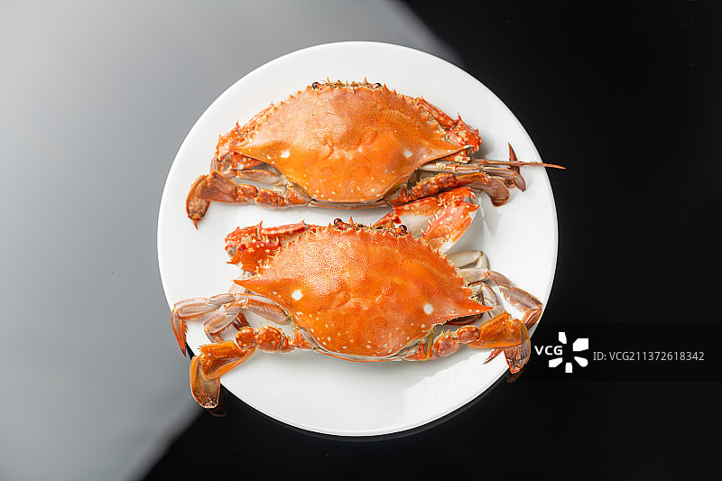 一盘梭子蟹摆放在黑色背景上图片素材