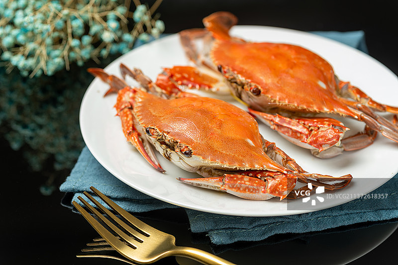 一盘梭子蟹摆放在黑色背景上图片素材
