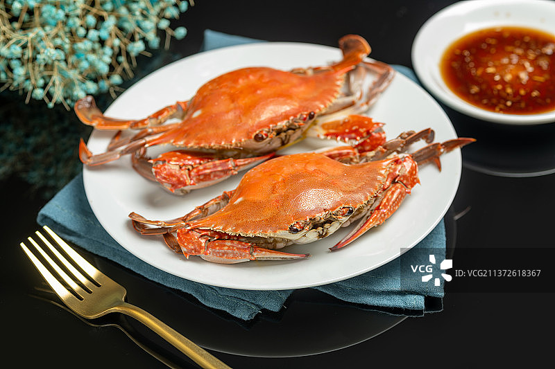 一盘梭子蟹摆放在黑色背景上图片素材