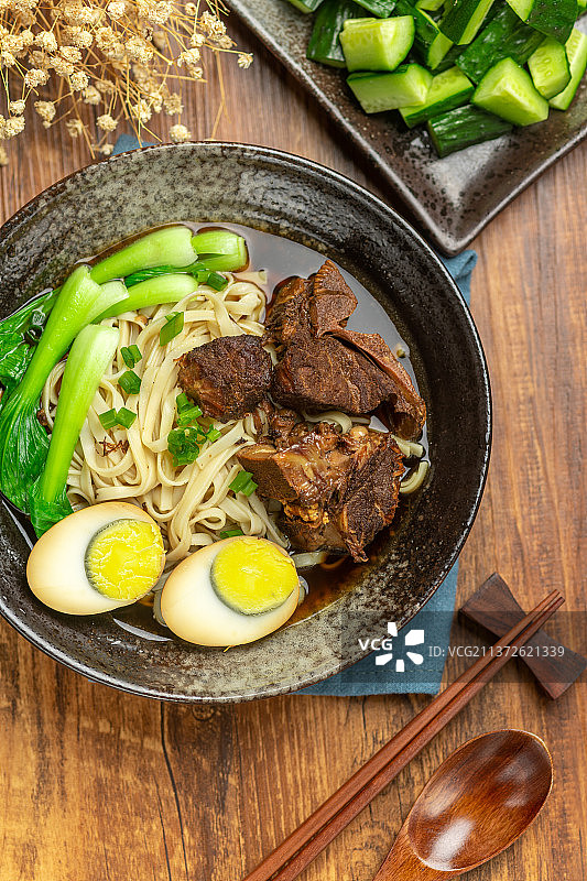 一碗排骨卤蛋面摆放在木桌面上图片素材