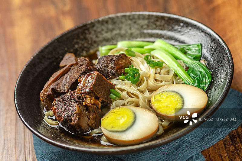 一碗排骨卤蛋面摆放在木桌面上图片素材