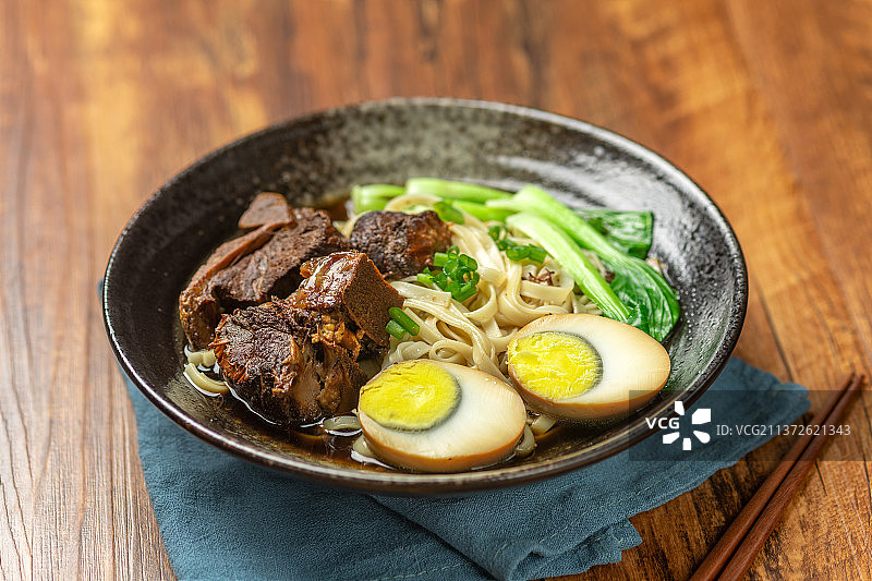 一碗排骨卤蛋面摆放在木桌面上图片素材