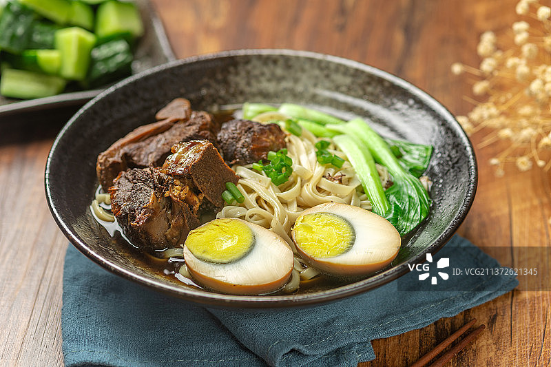一碗排骨卤蛋面摆放在木桌面上图片素材
