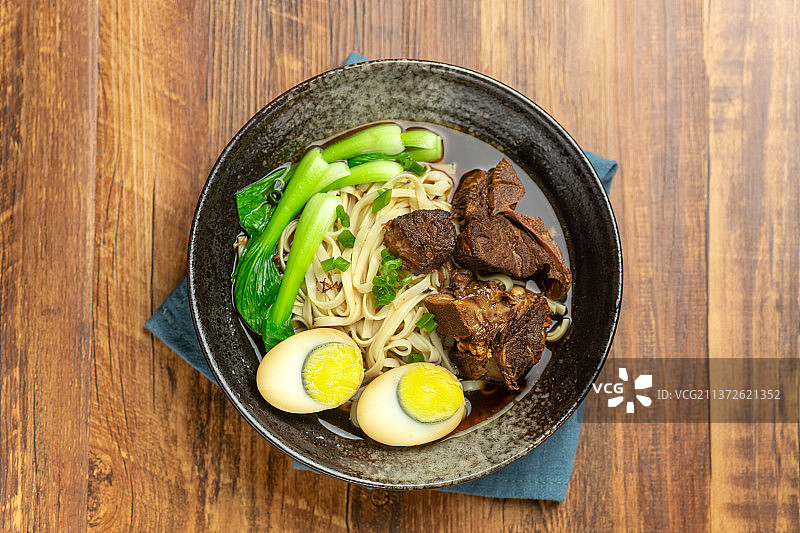 一碗排骨卤蛋面摆放在木桌面上图片素材