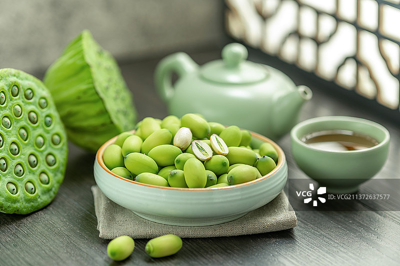 一盘莲子摆放在中式窗棂前的桌面上图片素材