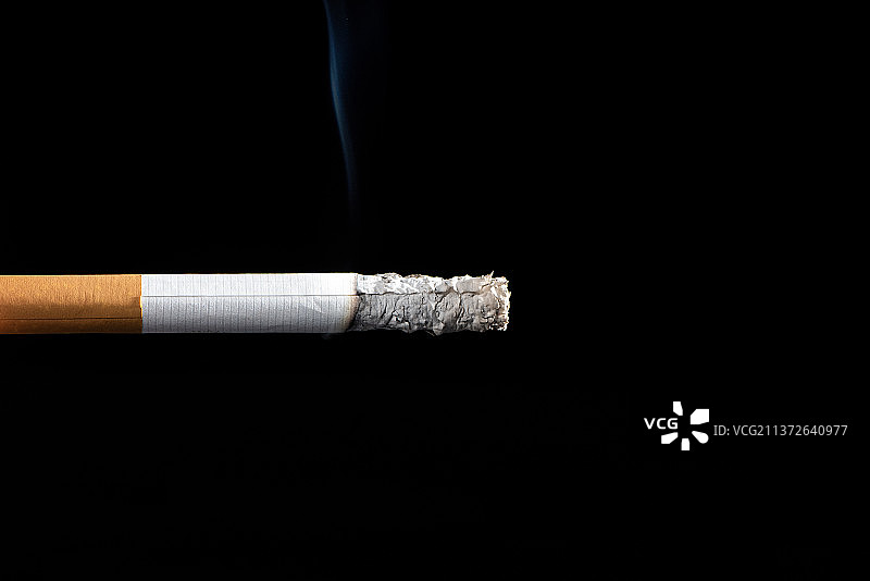 点燃的香烟抽烟，黑色背景图片素材