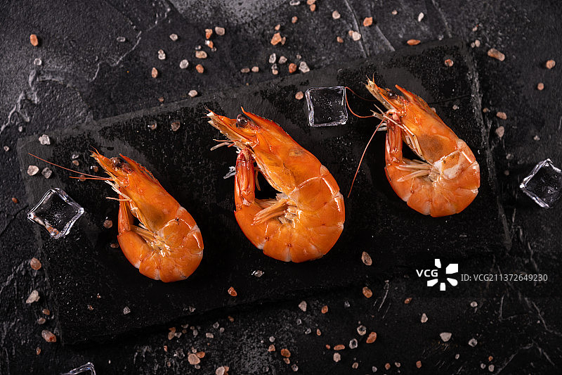 放在黑色石板上煮熟的红色大虾图片素材