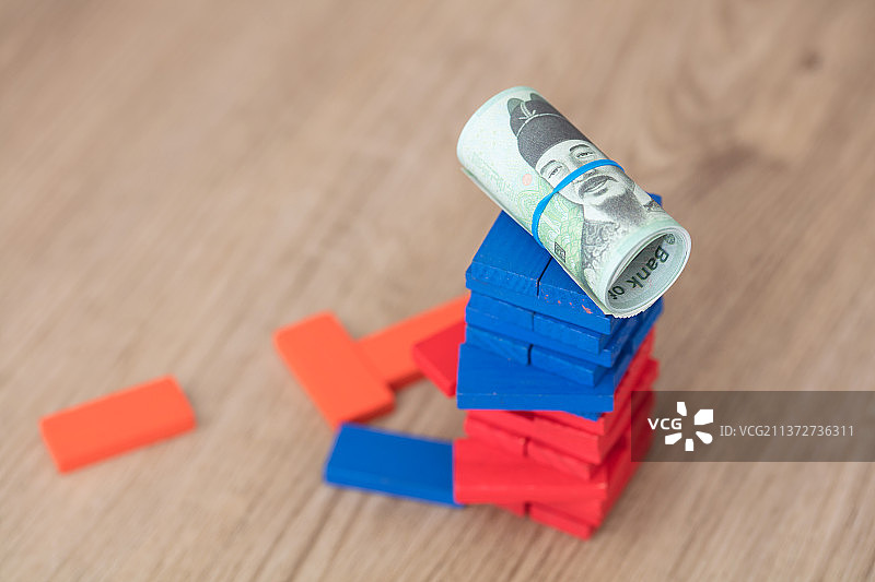 堆放很高的积木上一卷韩元钞票图片素材