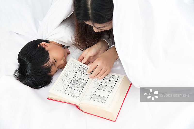 早晨床上妈妈在给孩子讲故事图片素材