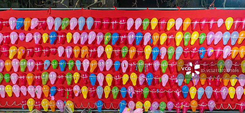 中国城市夜晚夜市拍摄主题，气枪打气球和排列整齐的彩色气球，户外无人图像摄影图片素材