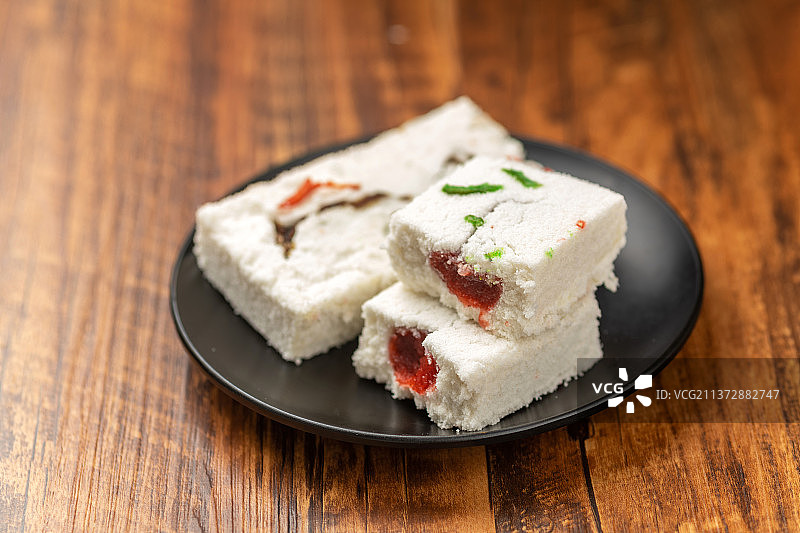 一盘糕干摆放在木桌面上特写图片素材