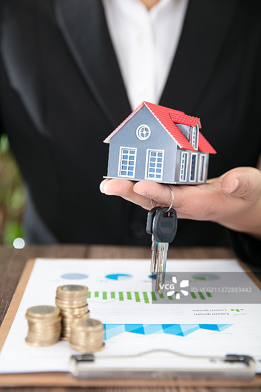 房地产销售手拿钥匙和新房模型交与业主图片素材