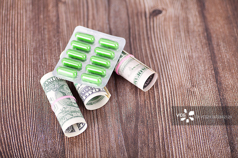 美元钞票和一板胶囊药品图片素材