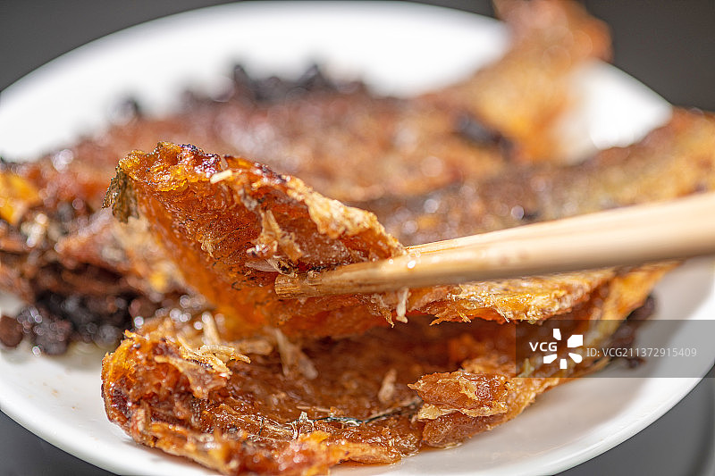 筷子夹豆豉鲮鱼特写黑色背景图片素材