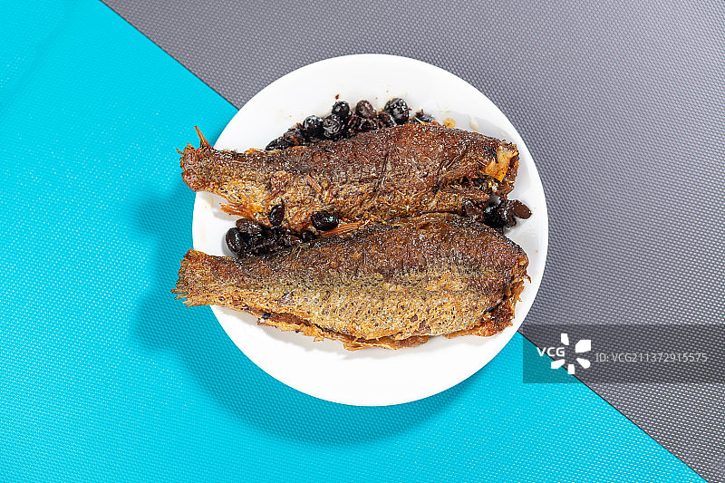 一盘豆豉鲮鱼红烧鱼特写蓝灰莫兰迪色系背景图片素材