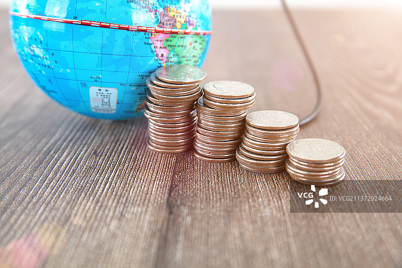 一个地球仪模拟在给一排美元硬币充电图片素材