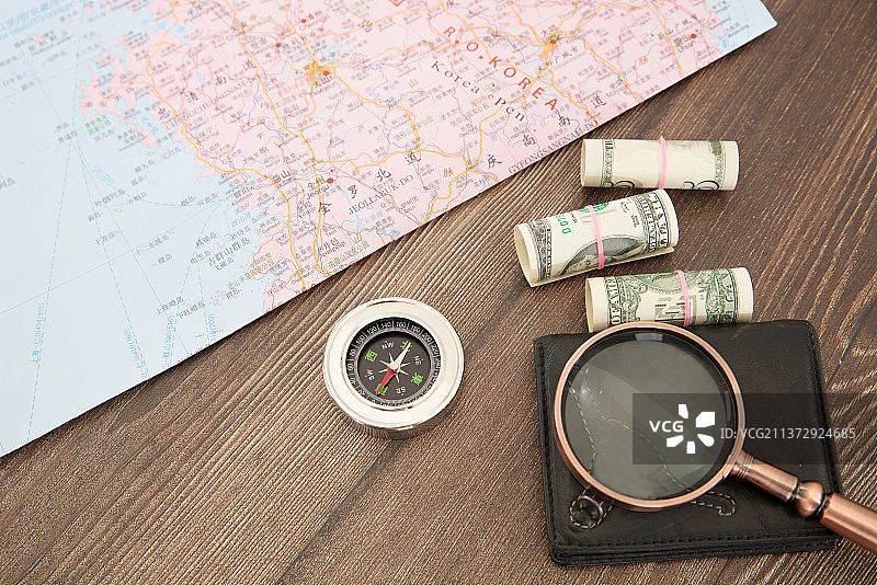 俯视桌子上的韩国地图和指南针及花费费用和放大镜图片素材