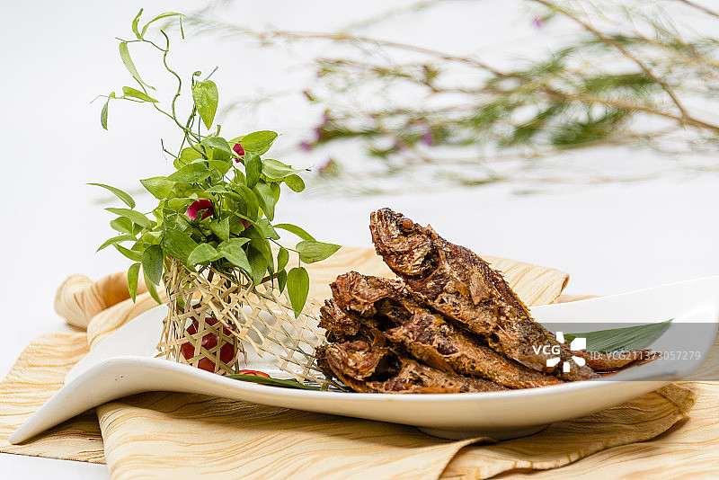 放在白色盘子上的中国菜——酥鱼图片素材