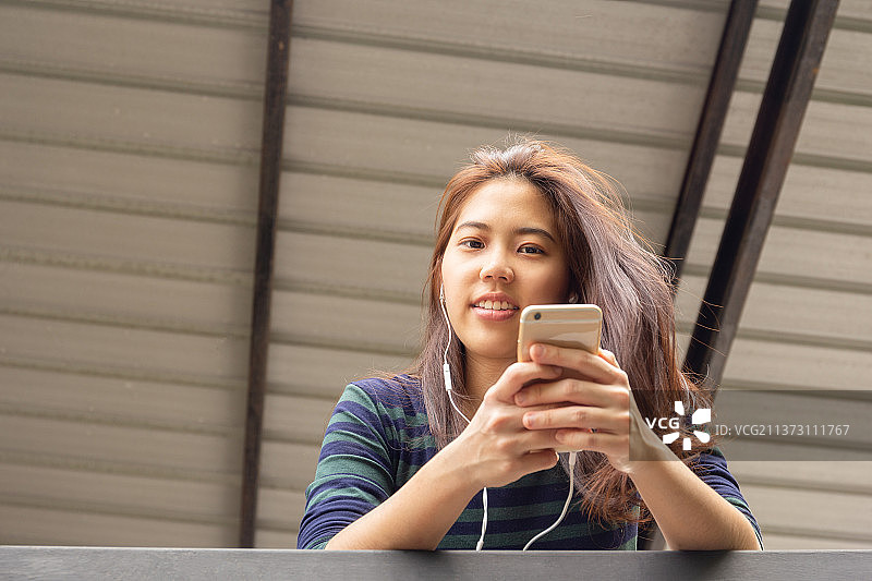 戴耳机听音乐的亚洲少女肖像，泰国图片素材