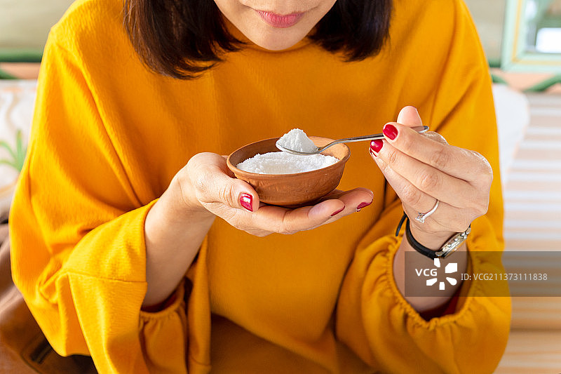 女人手拿满勺糖，健康护理概念，印度图片素材