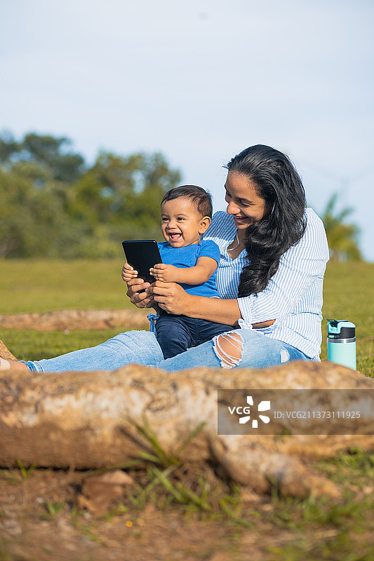 拉丁美洲母亲在绿色田野里和她的宝宝合影图片素材