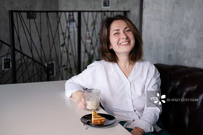 咖啡馆里身穿白色衬衫的自信深色头发女士肖像图片素材