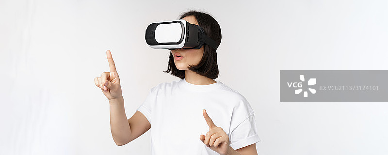 戴VR眼镜的亚洲女性画像，指向选择图片素材