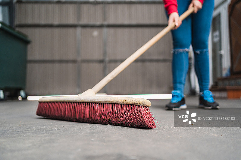 西班牙，用长扫帚清洁的女人特写图片素材