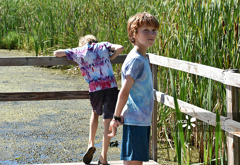 明尼苏达州明尼阿波利斯市，兄妹站在人行天桥上欣赏自然风光图片素材