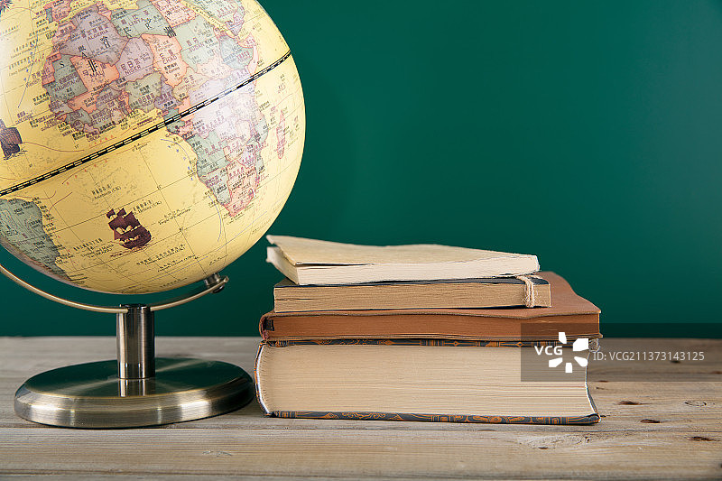 黑板前一个地球仪和一摞书图片素材