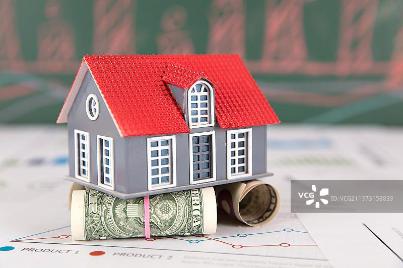 把小房子模型顶起来的美元钞票图片素材