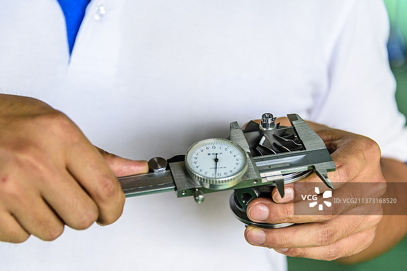 手持游标卡尺测量涡轮尺寸图片素材