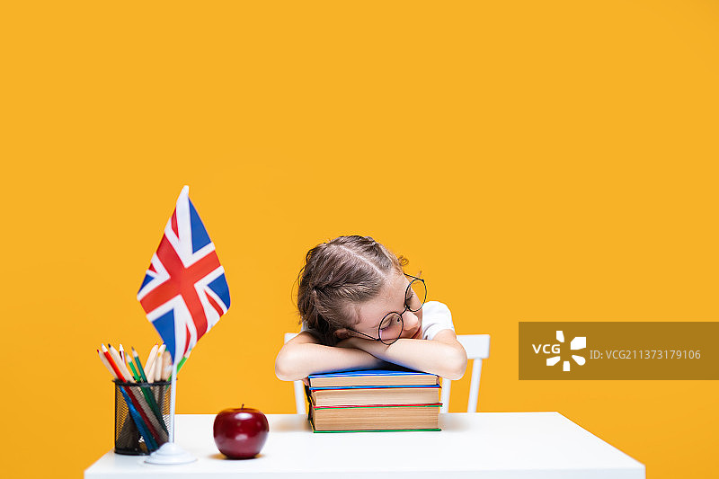 疲惫的白人女学生坐在书桌旁睡着了图片素材
