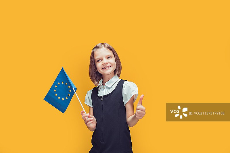 竖起大拇指，手持欧盟旗帜的微笑女学生图片素材