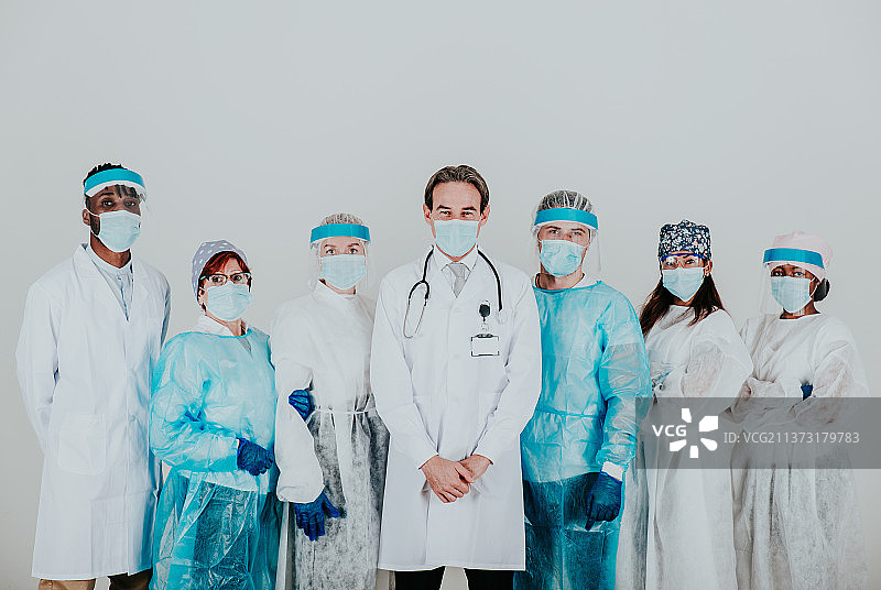 新冠病毒疫情期间的医护人员：自信的医生站在白色背景前图片素材