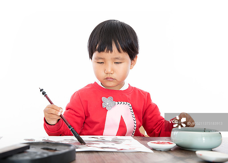 白背景里右手拿毛笔涂写左手拿印章的小女孩图片素材